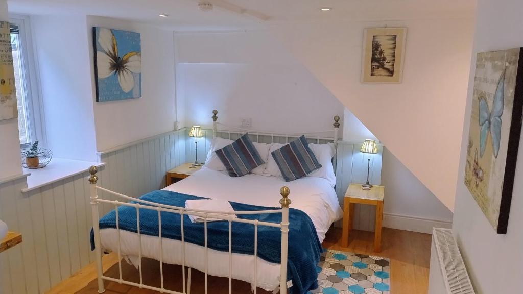 a bedroom with a bed with blue and white sheets at The Studio at St Cleer in Chippenham