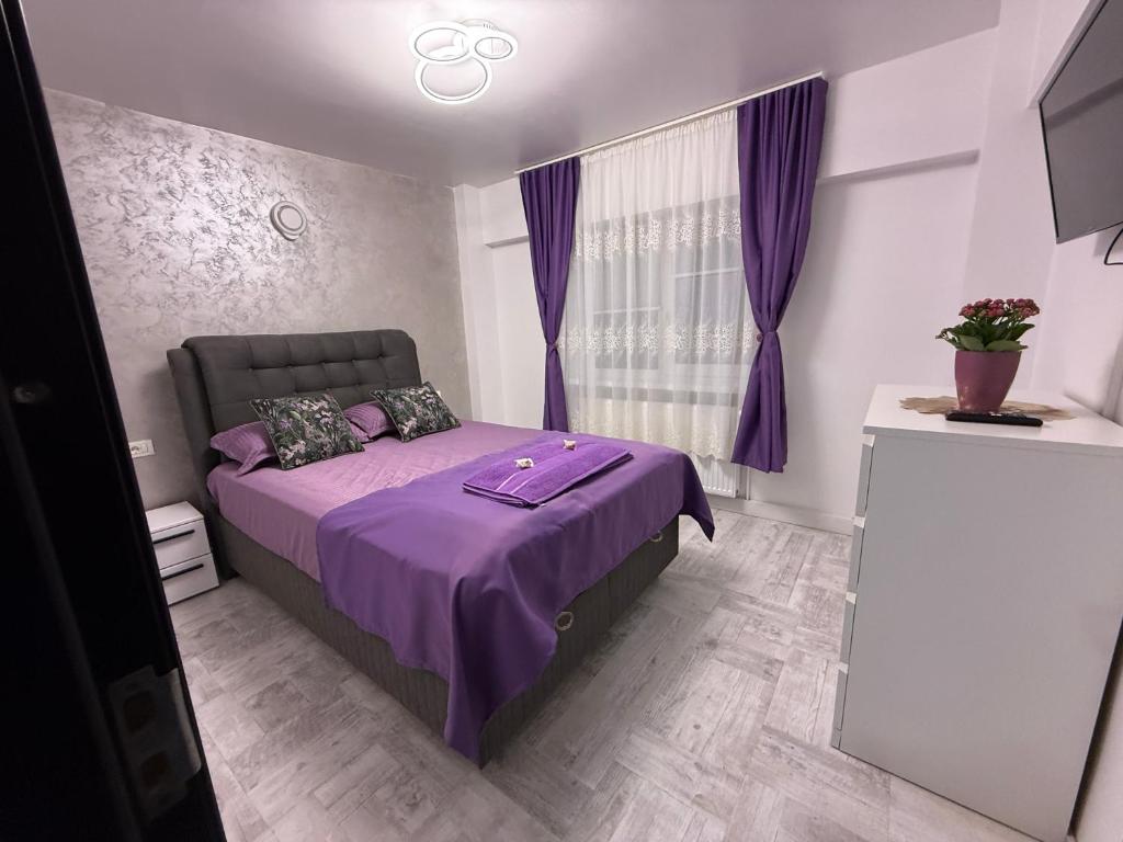 a bedroom with a purple bed with purple curtains at Ioana Home in Râmnicu Vâlcea