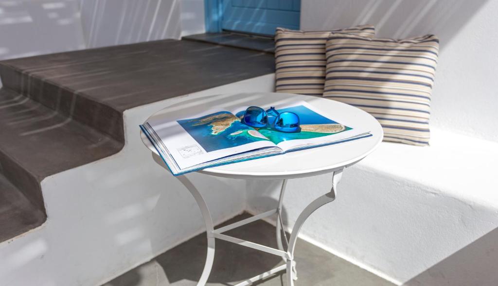 una mesa con un libro y un par de gafas azules. en Ammos Studios en Donoussa