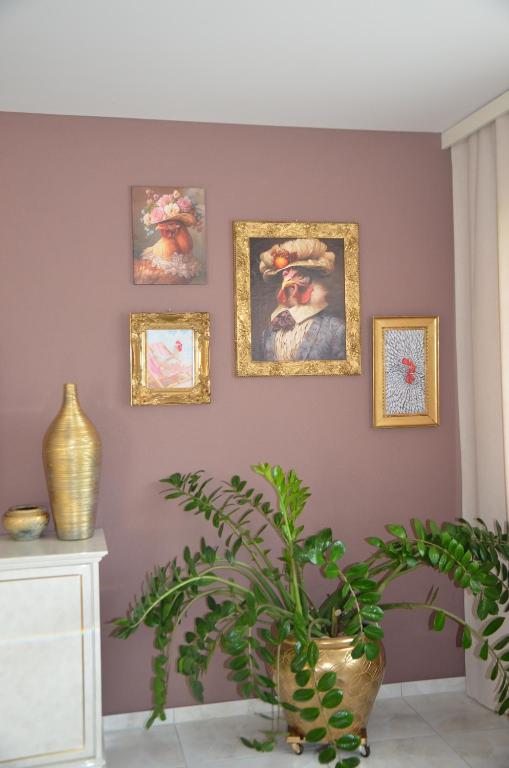 a room with paintings on the wall and a plant at Auszeitloge in Nottwil