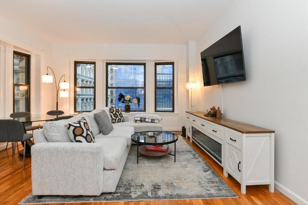 a living room with a couch and a tv at Elegant FiDi 3BR Condo - Private Elevator - Modern Luxury in New York