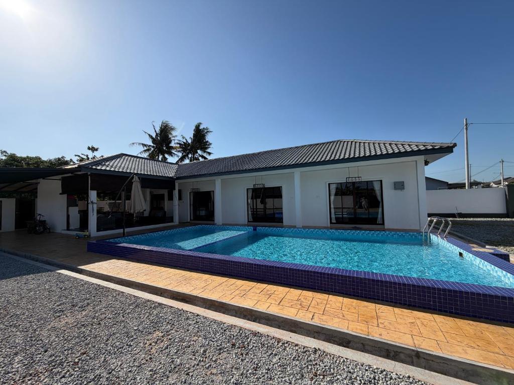 a swimming pool in front of a house at Untung5tay in Gua Sai