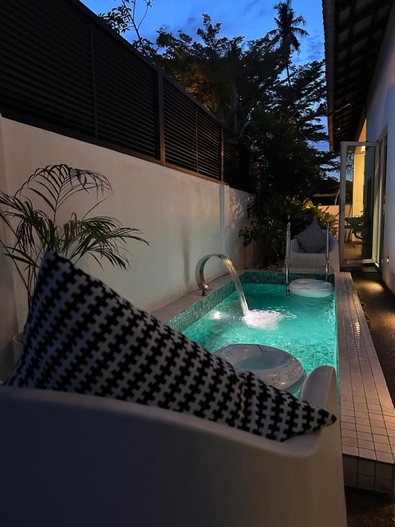 a swimming pool with a fountain in a backyard at The Lumber with Private Pool in Masjid Tanah