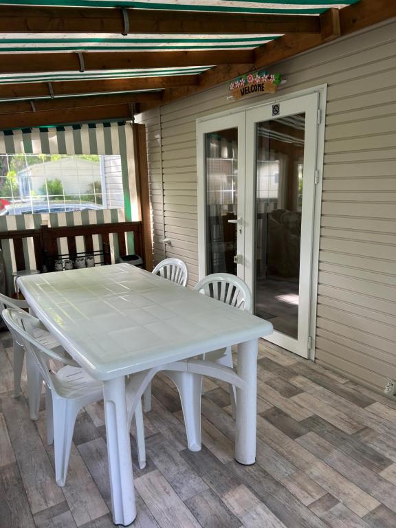 a white table and chairs on a patio at Mobilhome 592 FUNPASS NON INCLUS in Gastes