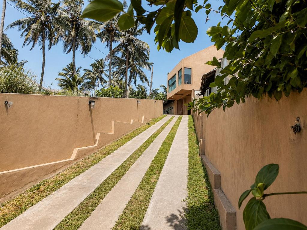 a walkway in front of a house with a fence at Villa Yuvin in Matara