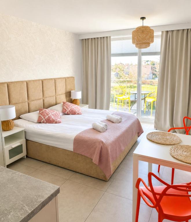 a bedroom with a bed with pink pillows on it at Apartamenty Sunny Stay Jastarnia in Jastarnia