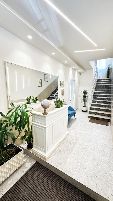 a large living room with stairs and plants at R&B Dimora Teodorico in Ravenna