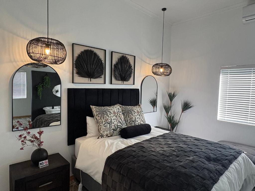 a bedroom with a bed and two mirrors at ikibiki in Beaufort West