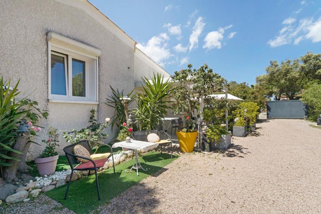 a garden with chairs and plants in front of a house at Le Pape - Chambre in Porticcio