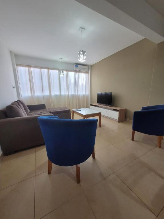 a living room with blue chairs and a couch at Alto Valle Home in Cipolletti