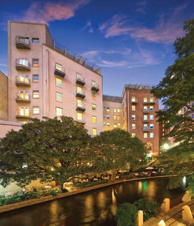a building next to a river in a city at Riverside Suites Resort 1BR Apartment in San Antonio