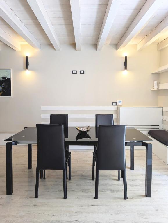 a dining room with a black table and chairs at The Superhost - The Loft in Crotone