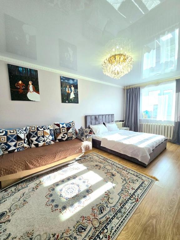 a bedroom with a bed and a large rug at Двухкомнатная "Аэропорт Астана" in Prigorodnyy