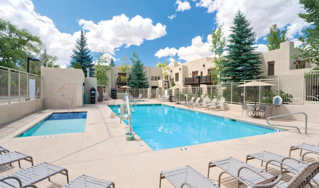 a swimming pool with lounge chairs and a resort at Taos Resort Studio Apartment in Taos