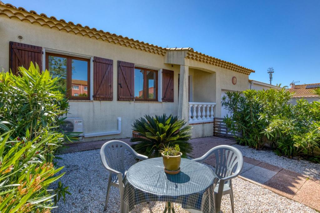 a table and chairs in front of a house at Gîtes Villa Beau Soleil Agde in Agde
