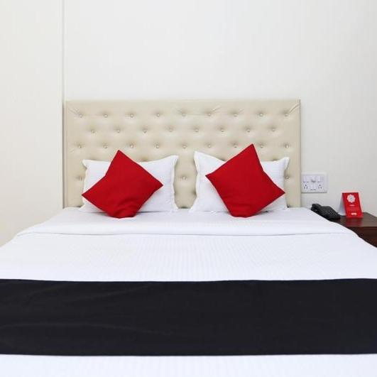 a bed with two red pillows on top of it at Triple Tree Hotels and Resorts in Bhubaneshwar