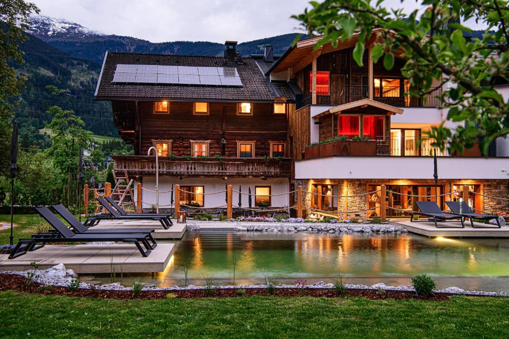 a house with a pool in front of it at Zillertaler Hofchalets Schustererhof in Stumm