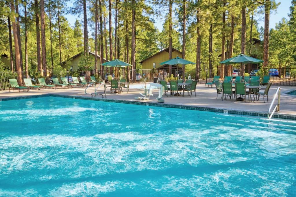 a swimming pool with chairs and a table and chairs at Pinetop Resort Studio Apartment in Pinetop-Lakeside