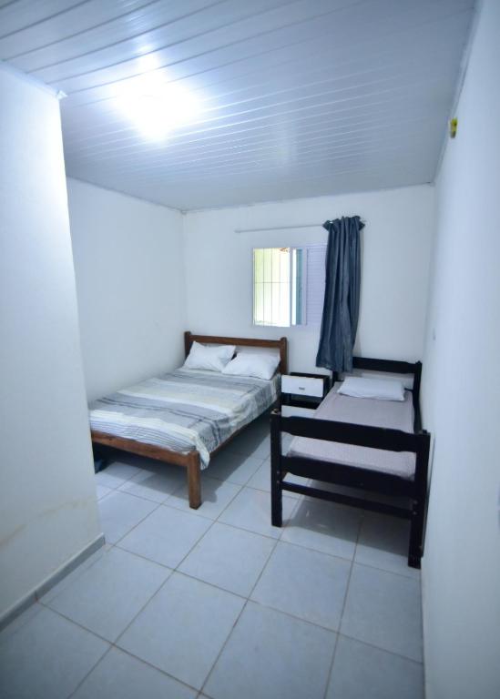 a white room with a bed and a window at Casa Rosi in Pitimbu
