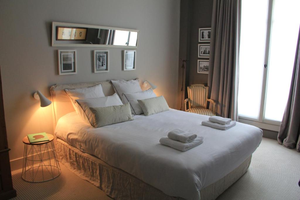 a bedroom with a large bed with towels on it at Villa du Square, Luxury Guest House in Paris