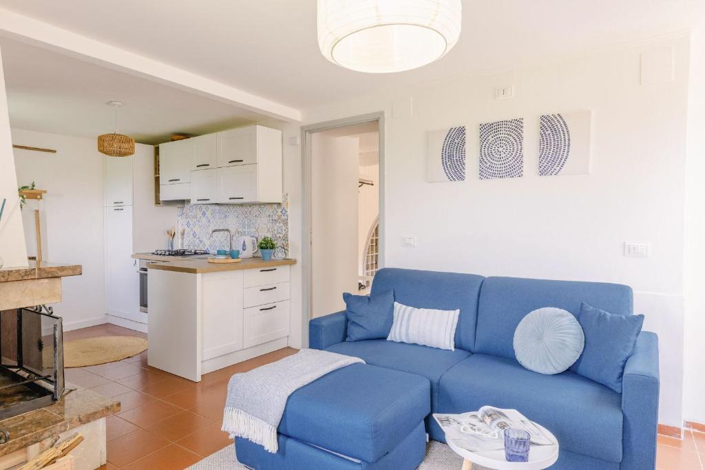 a living room with a blue couch and a kitchen at Italian Experience-La Terrazza nel Borgo in Marsciano