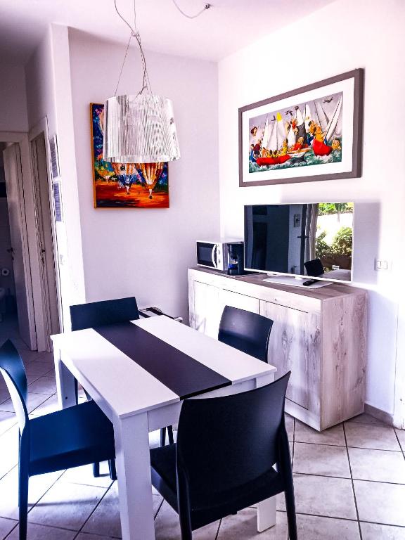 a dining room with a white table and chairs at Casa di Luga in Costa Paradiso