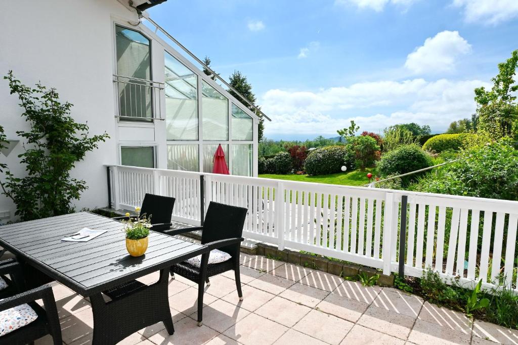eine Terrasse mit Tisch und Stühlen auf einem Balkon in der Unterkunft BayernBlick in Rimsting