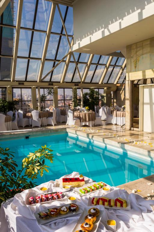 a swimming pool with food on a table in a building at Park Plaza Santiago in Santiago