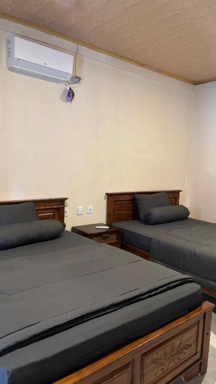 a bedroom with two beds and a fan at Villa Nacita in Bumbang
