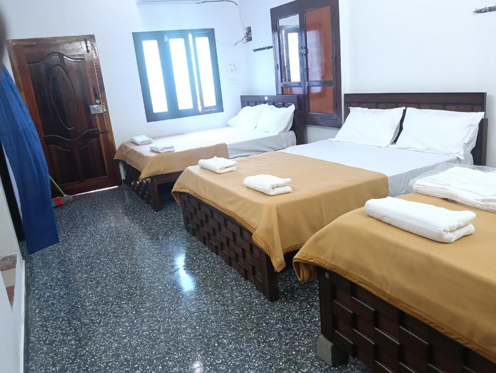 a hotel room with two beds with towels on them at natchiyar home stay in Rāmeswaram