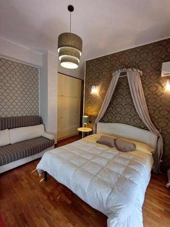 a bedroom with a large bed and a couch at Terre del Sud in Locri