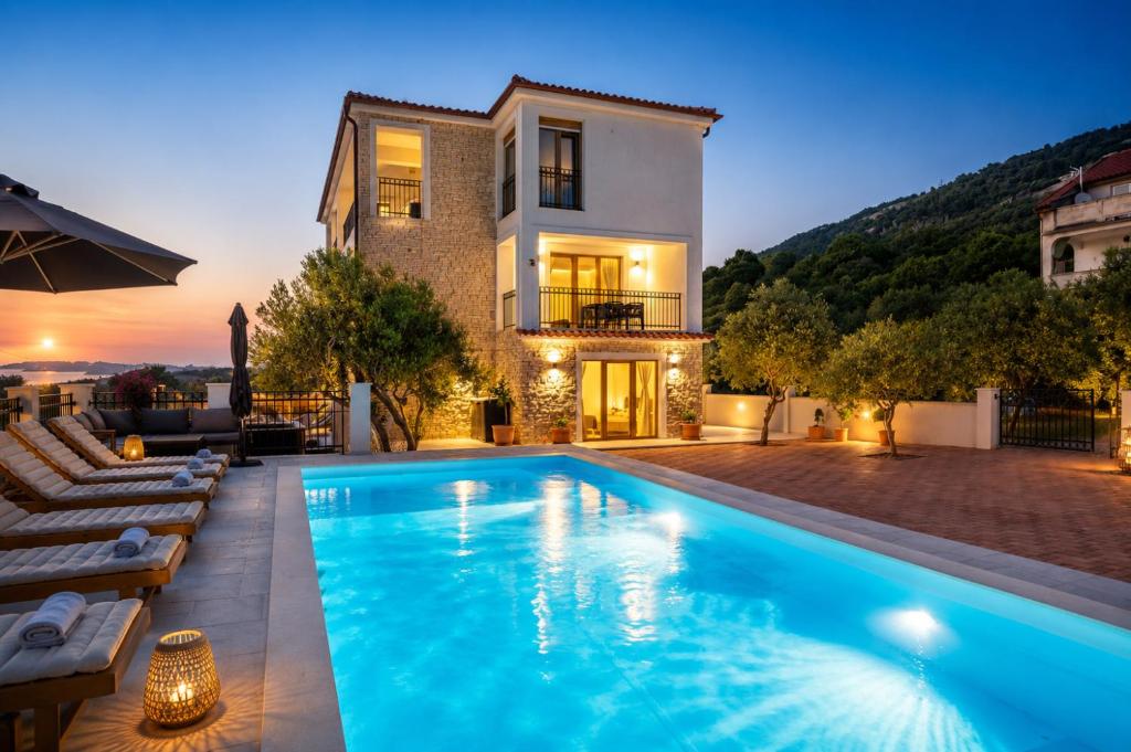 a villa with a swimming pool in front of a house at Villa Mianka - Luxury Apartments in Banjol
