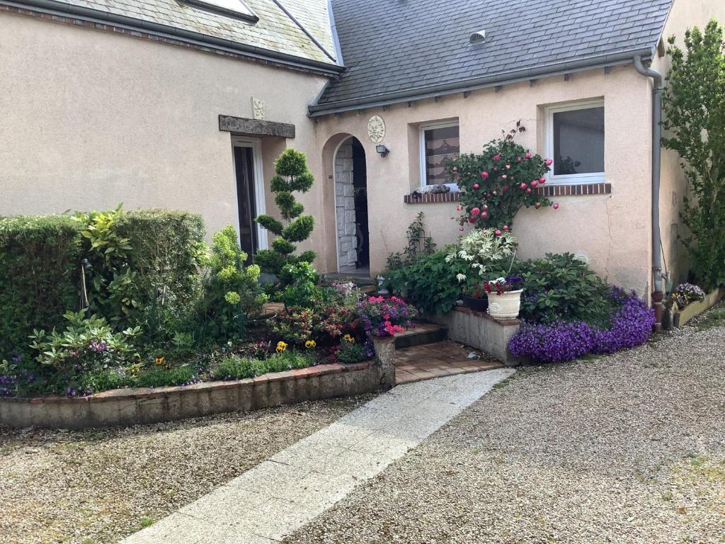 a house with a bunch of flowers in front of it at Les clés du temps in Essarts