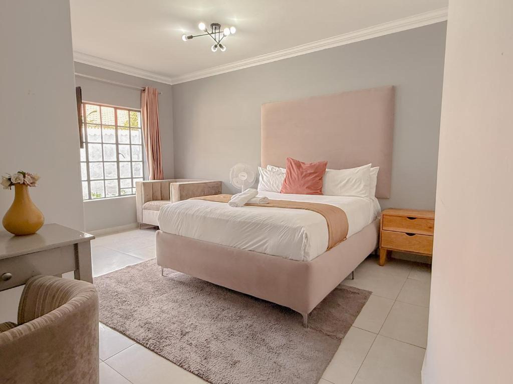 a bedroom with a large bed and a couch at Amoris on Anderson in Pretoria