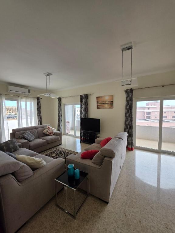 a large living room with couches and a tv at Vendome in Paceville