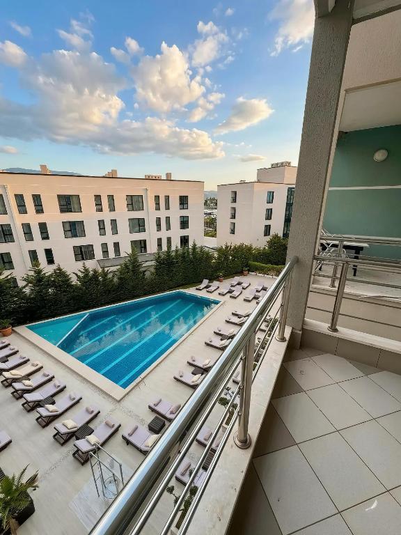 a balcony with lounge chairs and a swimming pool at Solis Apartments in Vlorë