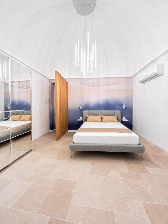 a bedroom with a large bed and a mirror at Luxury Way Blue Essence in Molfetta