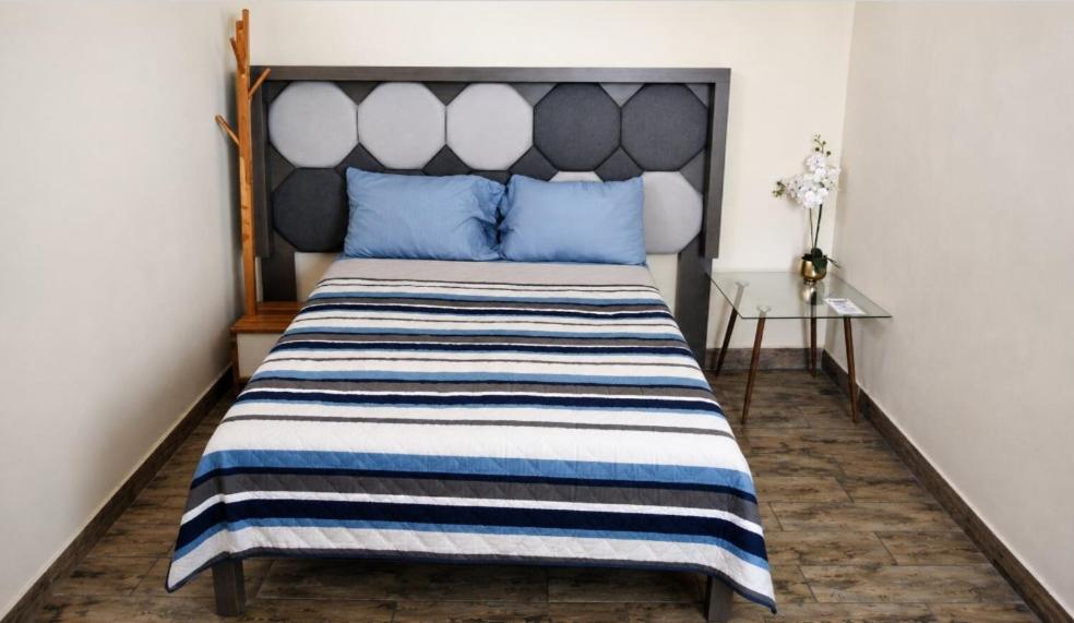 a bedroom with a large bed with blue pillows at Rose Room, Paseo Durango in Durango