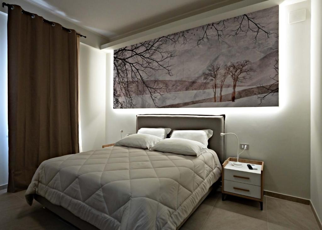 ein Schlafzimmer mit einem Bett und einem Gemälde an der Wand in der Unterkunft Max's Rooms in Termoli
