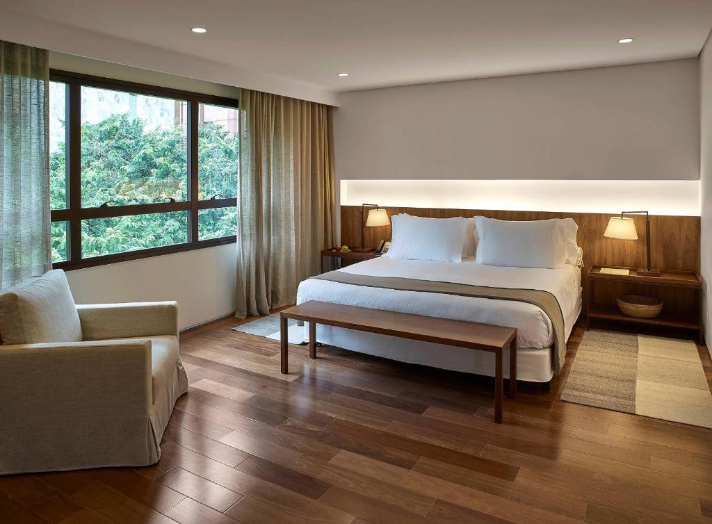 a bedroom with a large bed and a couch at Hotel Fasano Belo Horizonte in Belo Horizonte