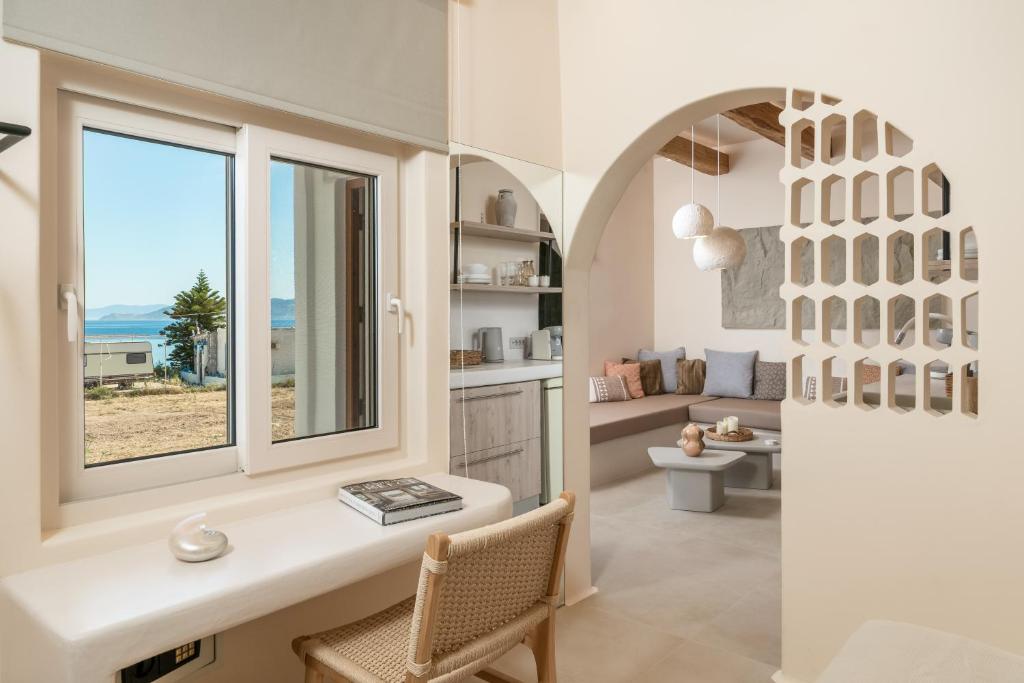 a living room with a window and a view of the ocean at Pnoé Lounge Suite in Mandrakia