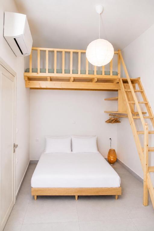 a bedroom with a bunk bed and a ladder at Mirtilo - Local Style, 1 Min from Main Beach in Kardamaina