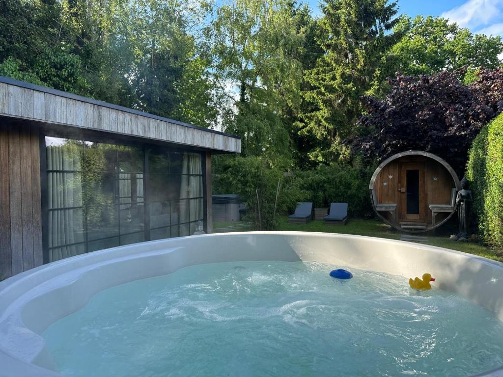 a hot tub with a toy in it in a backyard at maison Clavita in Genk