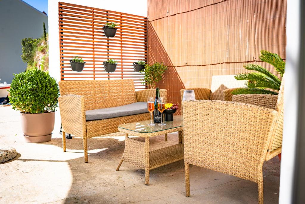 a patio with wicker chairs and a table with drinks on it at Apartment Eva Hvar in Hvar