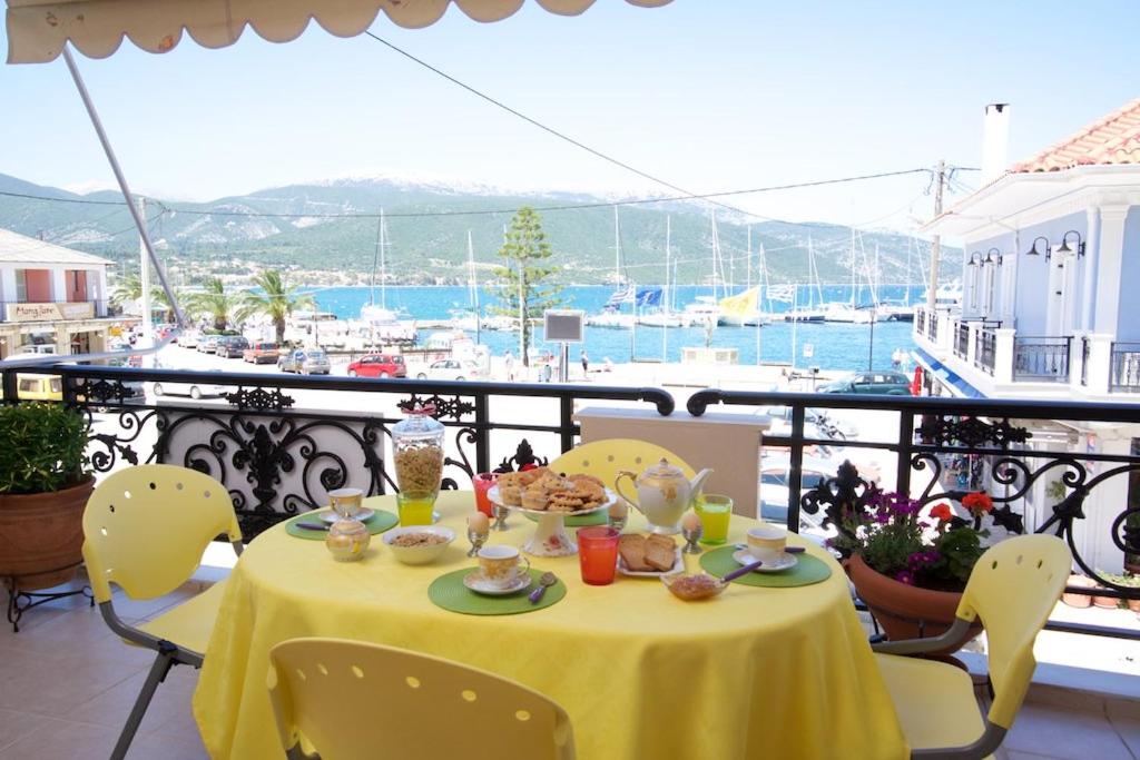 a table with food on a balcony with a view of the water at Sea Breeze Apartment in Sami