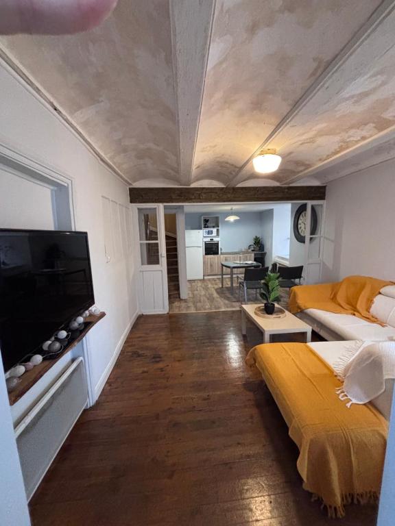 a living room with a bed and a flat screen tv at Comme à La Maison in Cayres