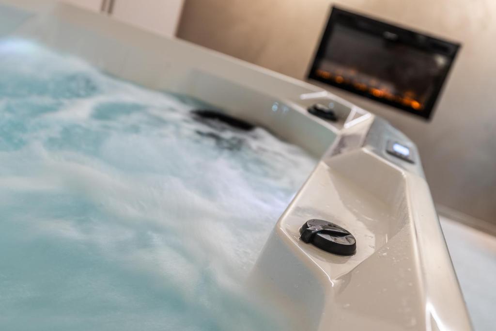 a white bathtub with a television in the background at Eifel Comfort Luxury Spa Suite mit privatem Whirlpool & Sauna in Pronsfeld
