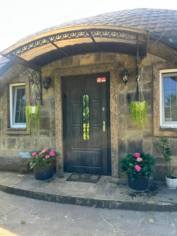 a front door of a stone house with two potted plants at Kupol for rest in Irpin