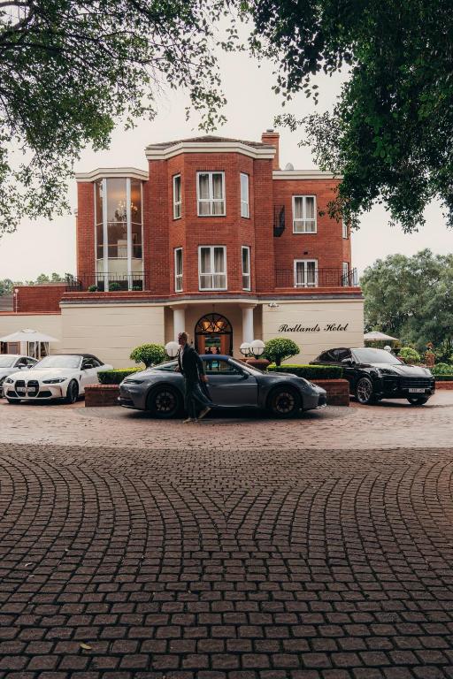 a couple sitting in their car in front of a building at Redlands Hotel in Pietermaritzburg