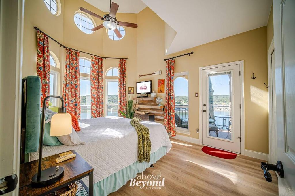 a bedroom with a bed and windows with a balcony at Sunset & Lakeview from Castle Turret on The Island in Lago Vista